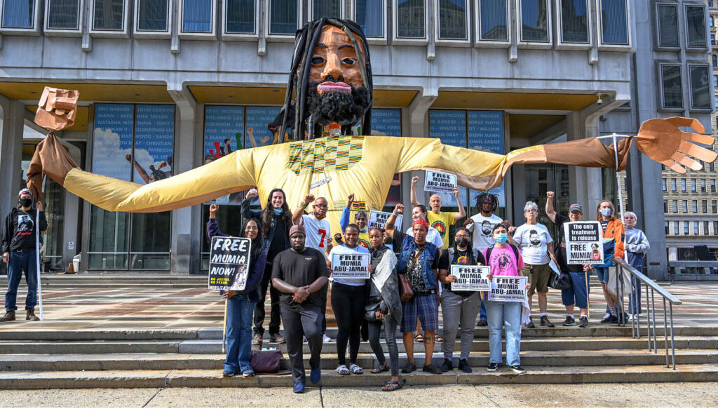 Demonstrators and Giant Mumia Puppet